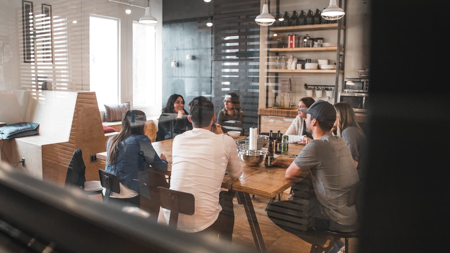 A team gathered around a long table in a shared workspace