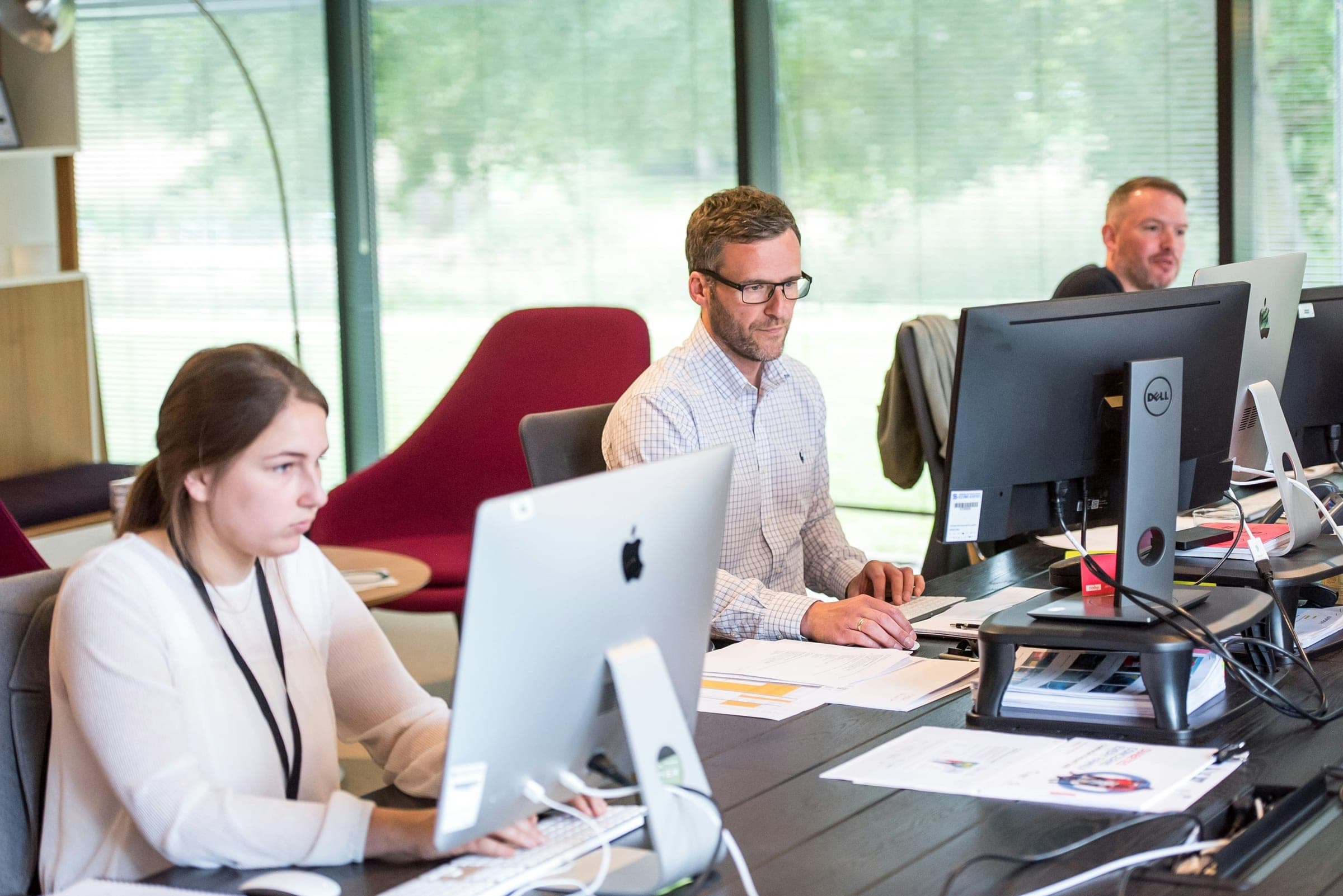 Team members working at computer workstations in an open office